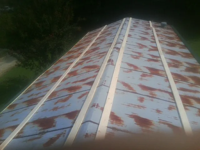 Rusted metal roof panels with new wood purlins before replacement — Storm Damage Roof Repair in Sandy by Roofing Brothers