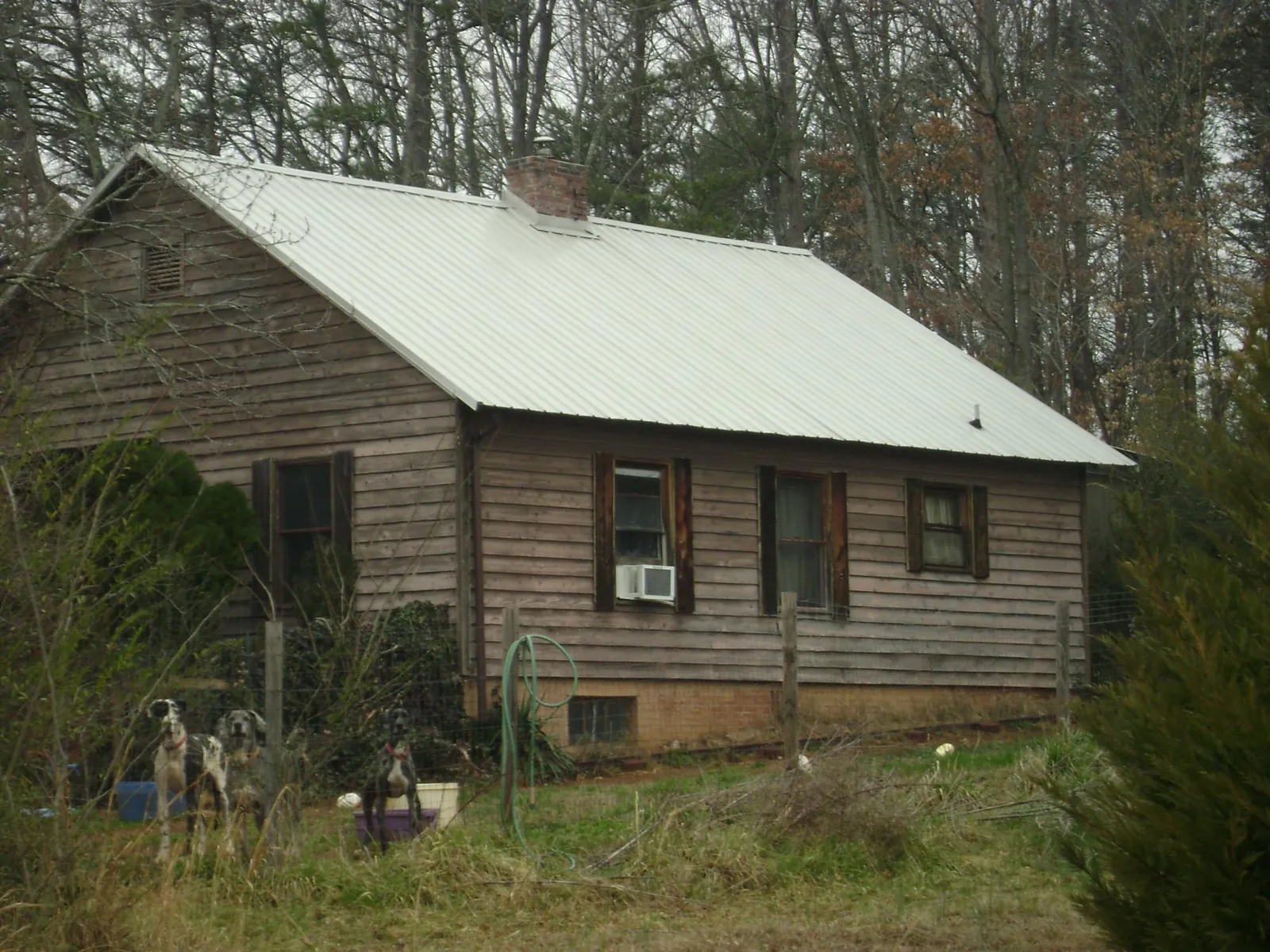 White metal roof on an old wood sided farmhouse, from a Metal Roof Installation job in Sandy